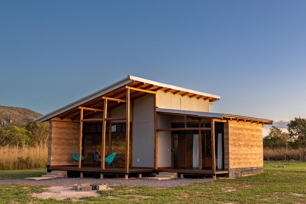 una casa pequeña con una gran puerta de cristal en Villa Taipas - Chalé Iepê, en Cavalcante