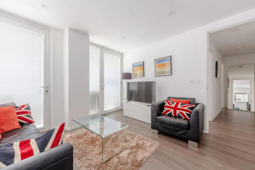 Modern 2BD Flat with a Balcony - Wandsworth في لندن: غرفة معيشة بها أريكة وتلفزيون