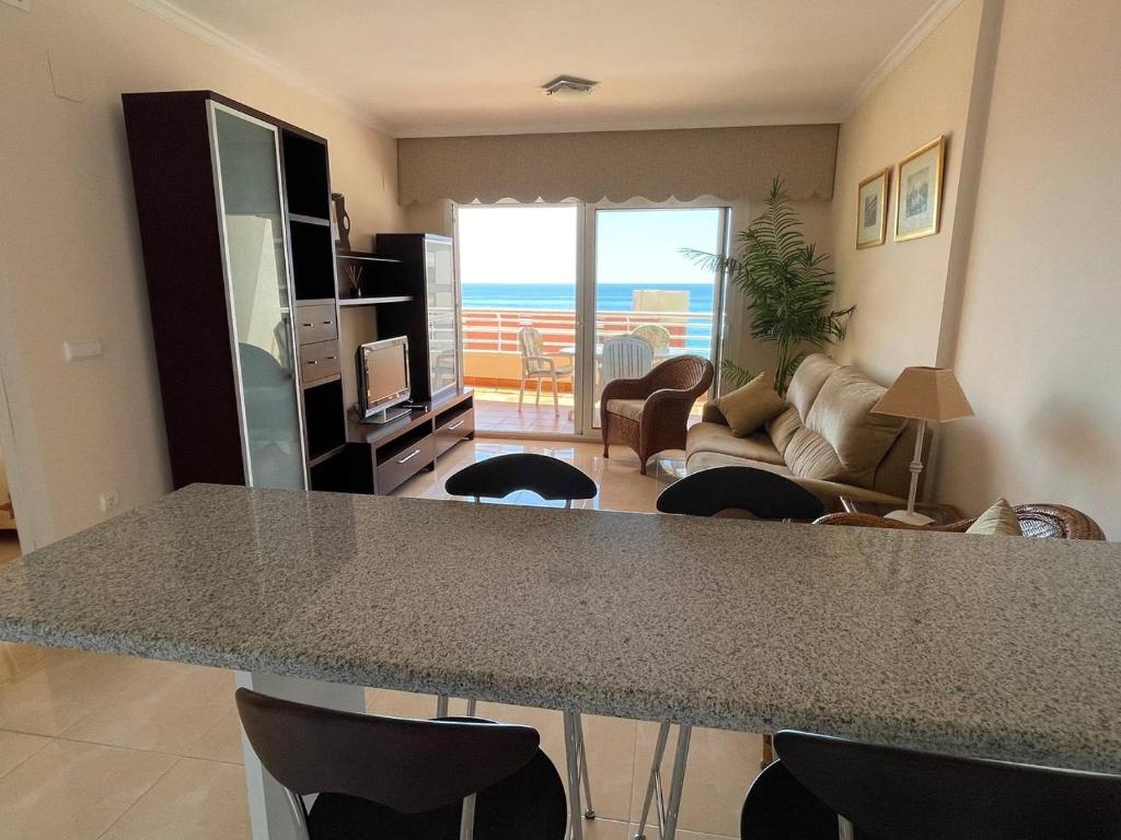 kuchnia i salon ze stołem i krzesłami w obiekcie Playa de Oro con Parking w mieście Calpe