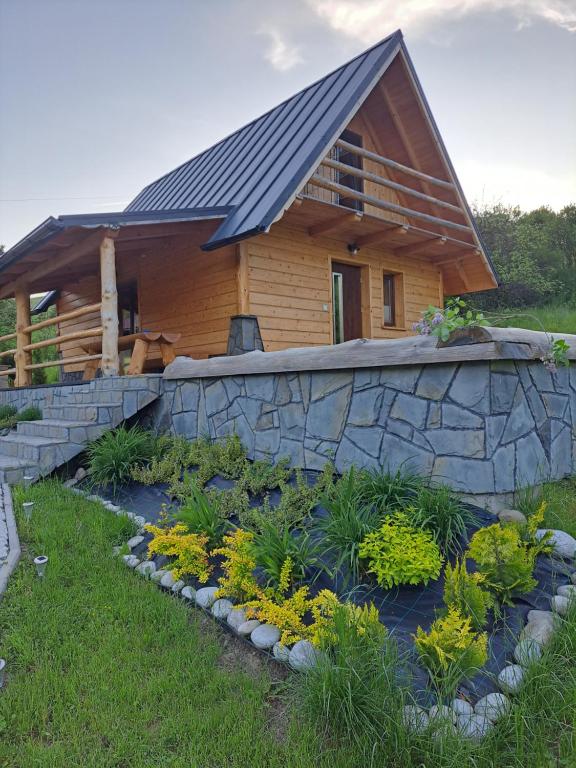 a house with a slate roof and a stone wall at Domek Pod Tylką in Grywałd