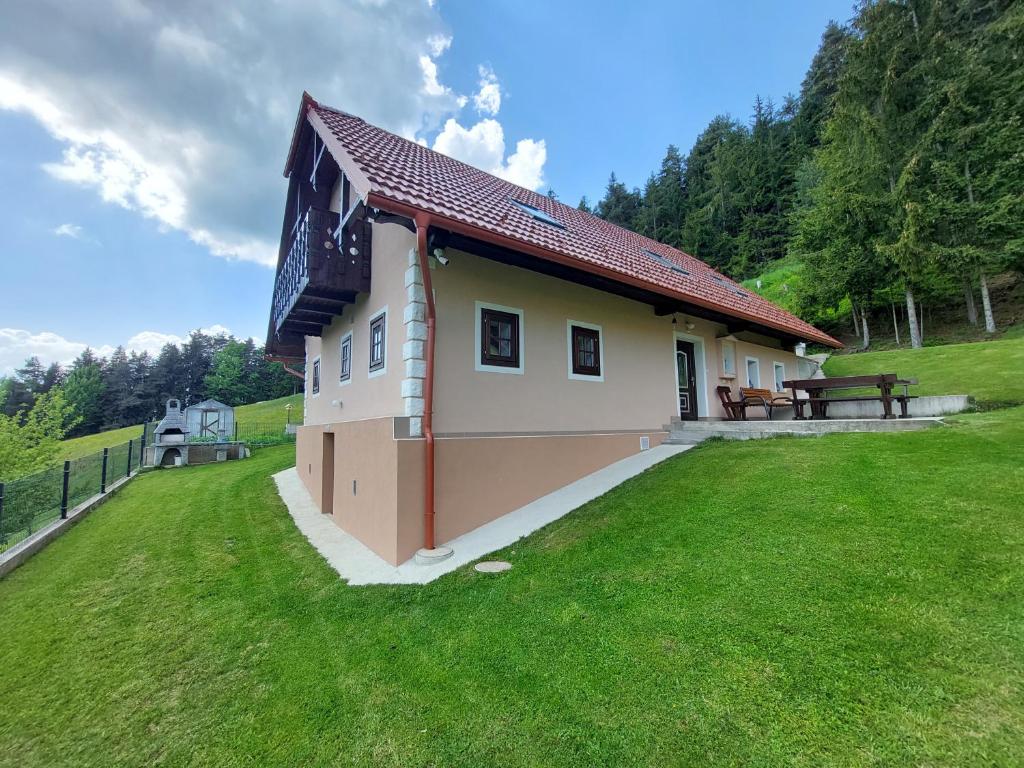 a small house with a grassy yard in front of it at Sunflower House with SPA and Sauna in Vitanje