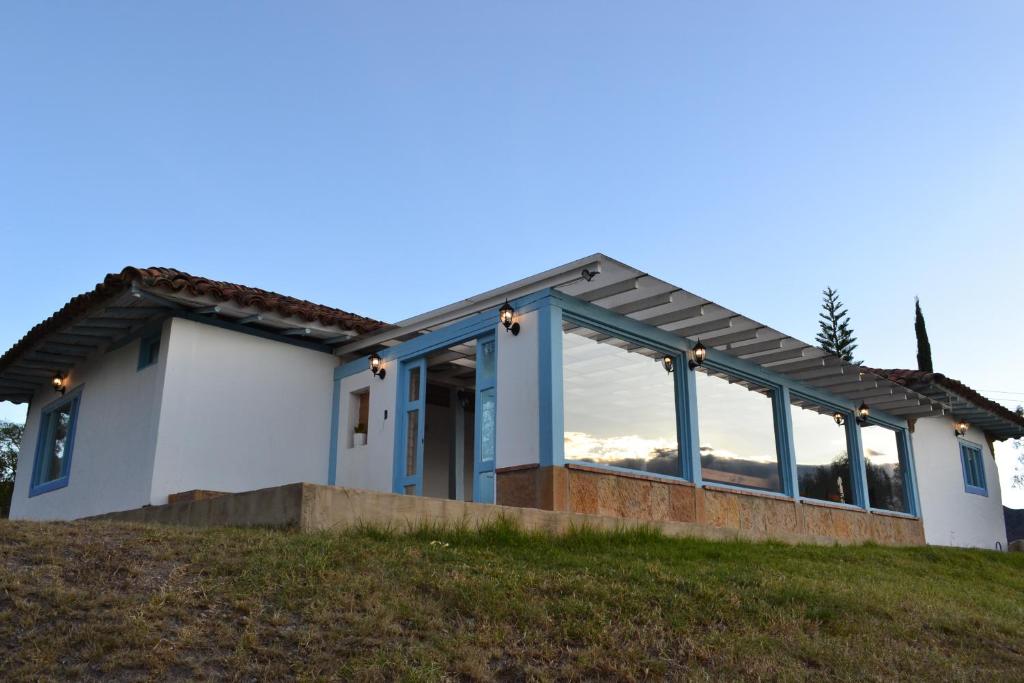 una casa con muchas ventanas en una colina en Casa Coclín - Paraíso Campestre, en Sáchica