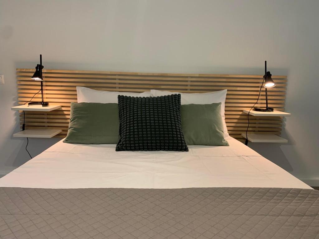 duże łóżko z 2 poduszkami i 2 światłami na górze w obiekcie SP Central Loft w mieście Wolos