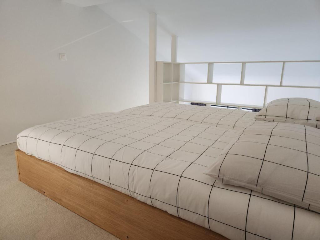 a bedroom with a large white bed with a headboard at Aaki Apartment Diegten in Diegten