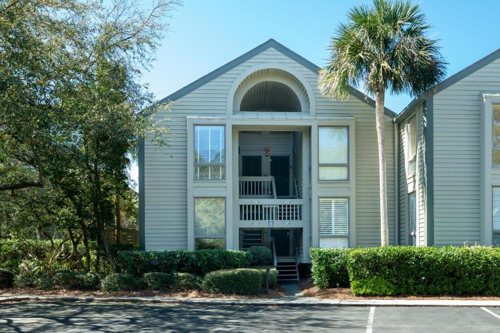 una casa con una palmera delante en 1385 Pelican Watch Villa, en Seabrook Island