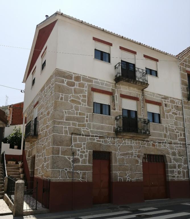 an old stone building with two doors and two balcony at Casa do César Douro Guest House in Tabuaço