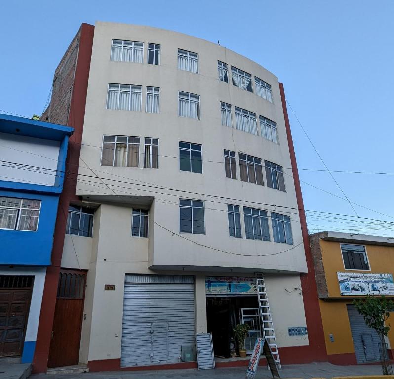 a tall white building with a lot of windows at Hospedaje Arequipa in Ayacucho