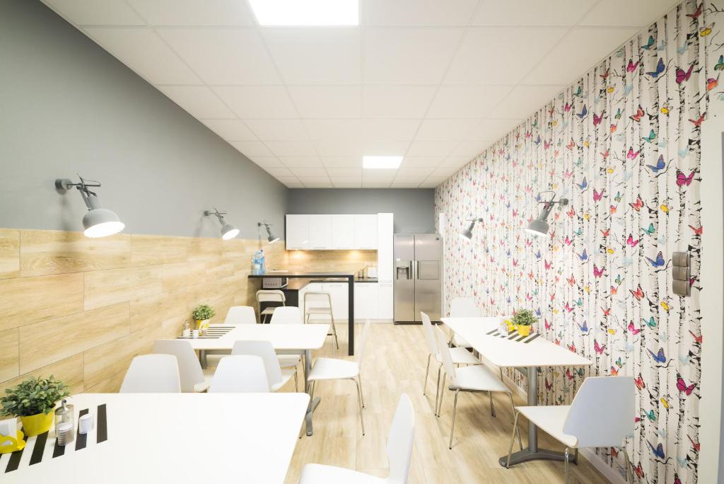 una sala da pranzo con tavoli bianchi e sedie bianche di Hostel Filip 2 a Danzica