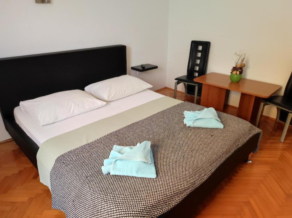 a bedroom with a bed with two towels on it at Rooms Carija in Trogir