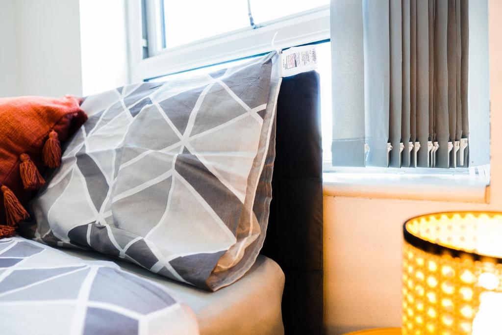 a pillow sitting on top of a couch next to a window at Bohemian Chic Retreat in Liverpool