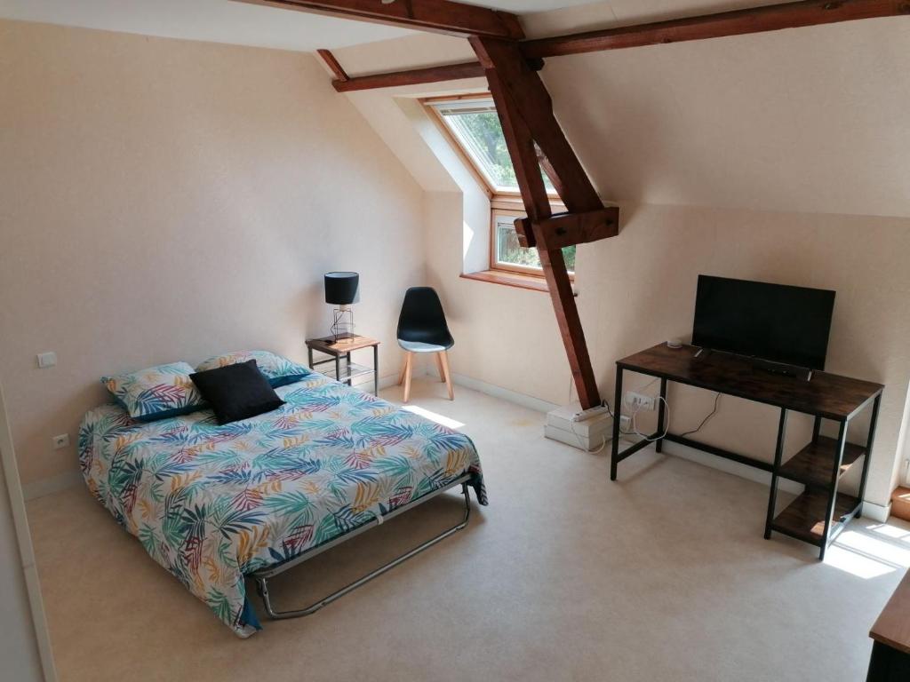Schlafzimmer mit einem Bett, einem Schreibtisch und einem Fenster in der Unterkunft Studio avec vue sur la Baie in Avranches