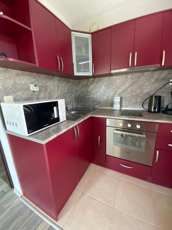 バルチクにあるApartments Vistaのキッチン(赤いキャビネット、電子レンジ付)