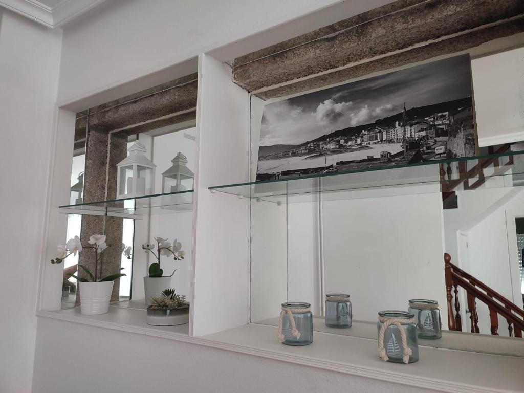 een kamer met een raam met vazen op een plank bij Piso Sol in Laxe