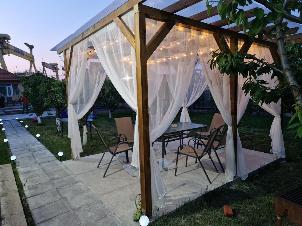 a gazebo with a table and chairs under it at Căsuța din livadă in 2 Mai