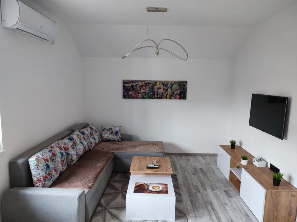 ein Wohnzimmer mit einem Sofa und einem Tisch in der Unterkunft Bella apartman in Brčko