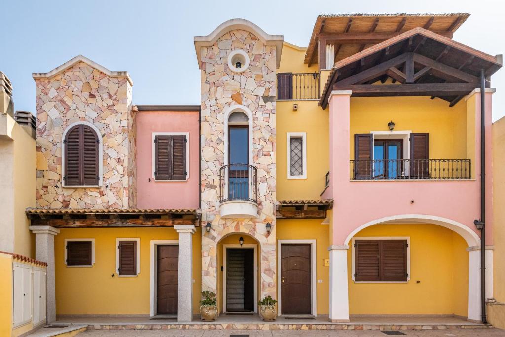 eine Reihe farbenfroher Häuser mit einem Uhrturm in der Unterkunft La Casa di Francy in Villasimius