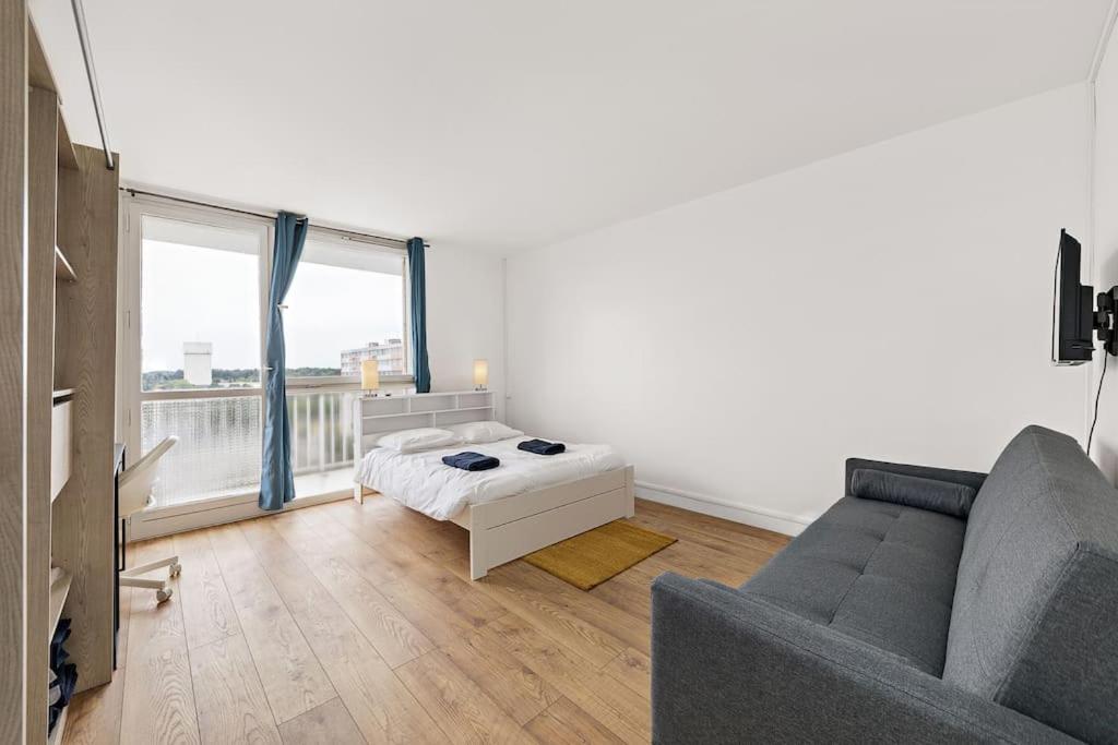 a living room with a bed and a couch at Red-10 Places+FreeParkingGratuit-5beds-Wifi/Zenith in Saint-Étienne-du-Rouvray