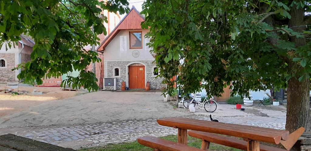 un banco de madera sentado bajo un árbol frente a una iglesia en Ubytování Na sklepě u Procházků, en Pouzdřany