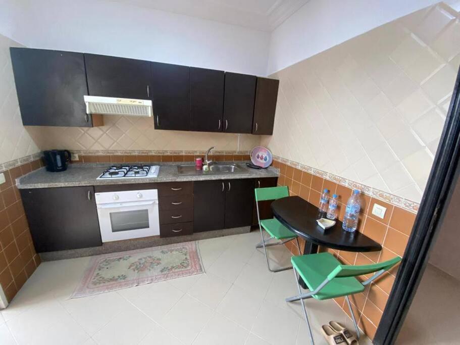 a kitchen with a sink and a table and a stove at view apartments larache in Larache