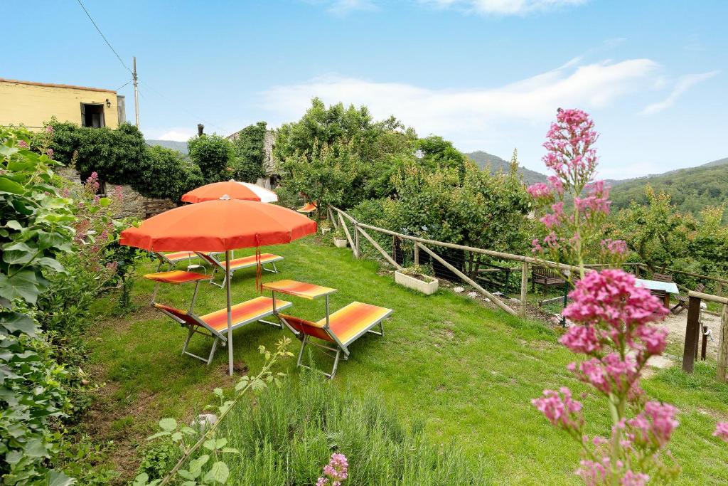 einen Tisch und Stühle mit Sonnenschirm in einem Garten in der Unterkunft Villa Luisa in Vezzi Portio