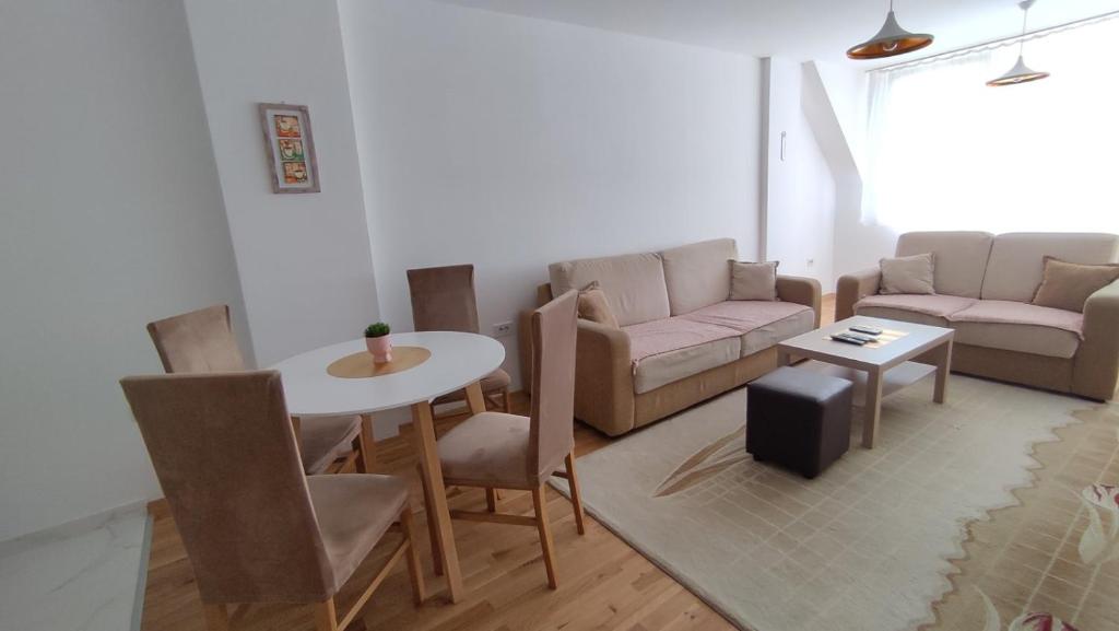 uma sala de estar com um sofá e uma mesa em Sunny Guest House em Skopje