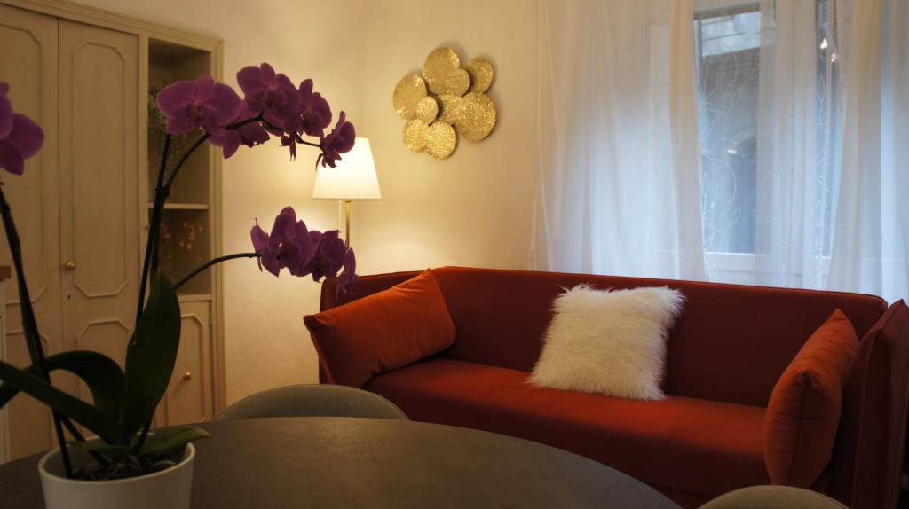 sala de estar con sofá rojo y almohada blanca en Casa Blanche, en Fanano