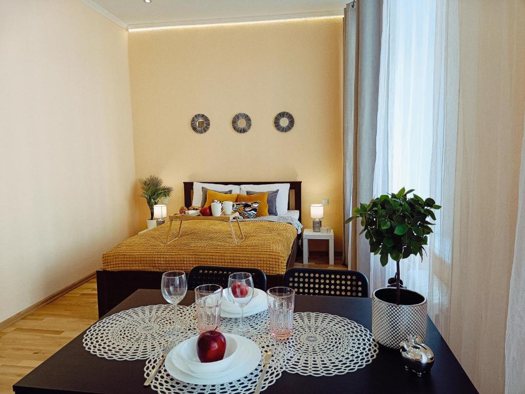a bedroom with a bed and a table with wine glasses at Centrally located Studio apartment in Riga
