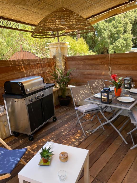 d'une terrasse avec un grill, une table et des chaises. dans l'établissement Appartement de charme, à Six-Fours-les-Plages