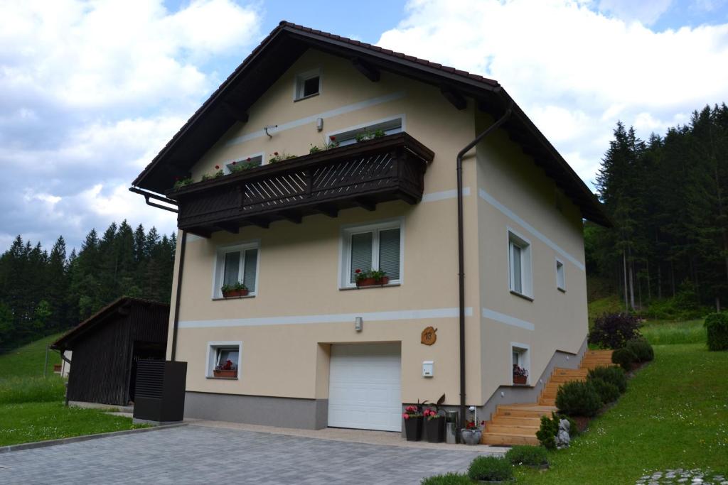 uma grande casa branca com um telhado preto em Apartma ob potoku em Luče