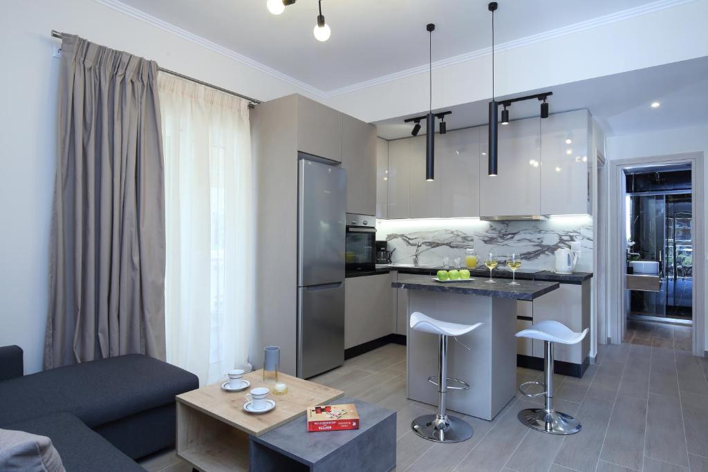 a kitchen and living room with a couch and a table at Kallithea Guesthouse in Nydri