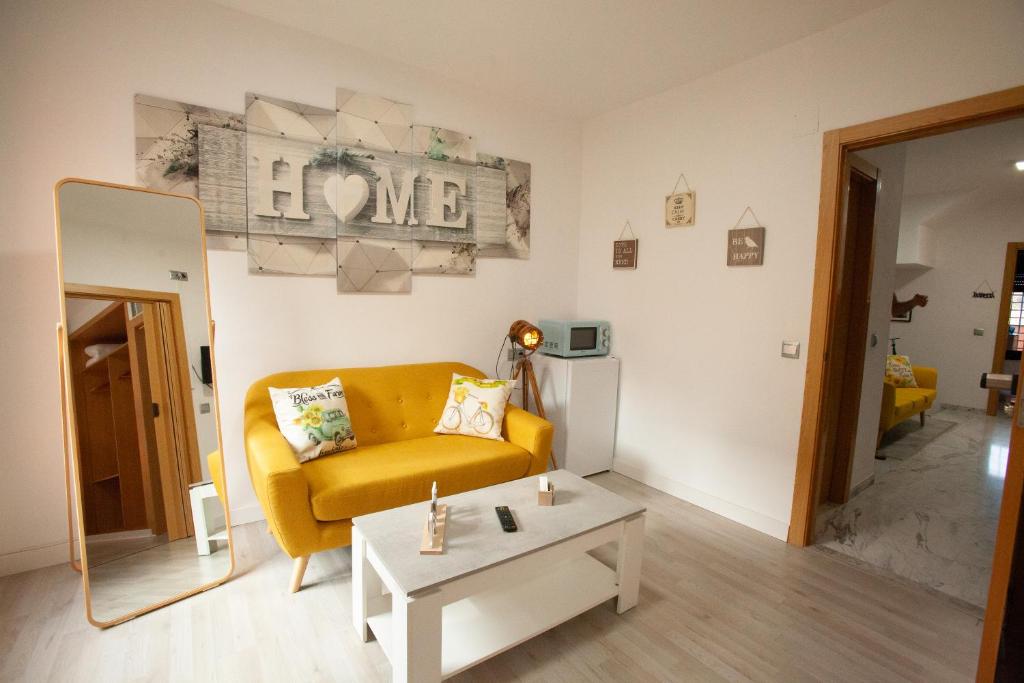 een woonkamer met een gele bank en een tafel bij Suites Beach Nature by Alterhome in Vélez-Málaga