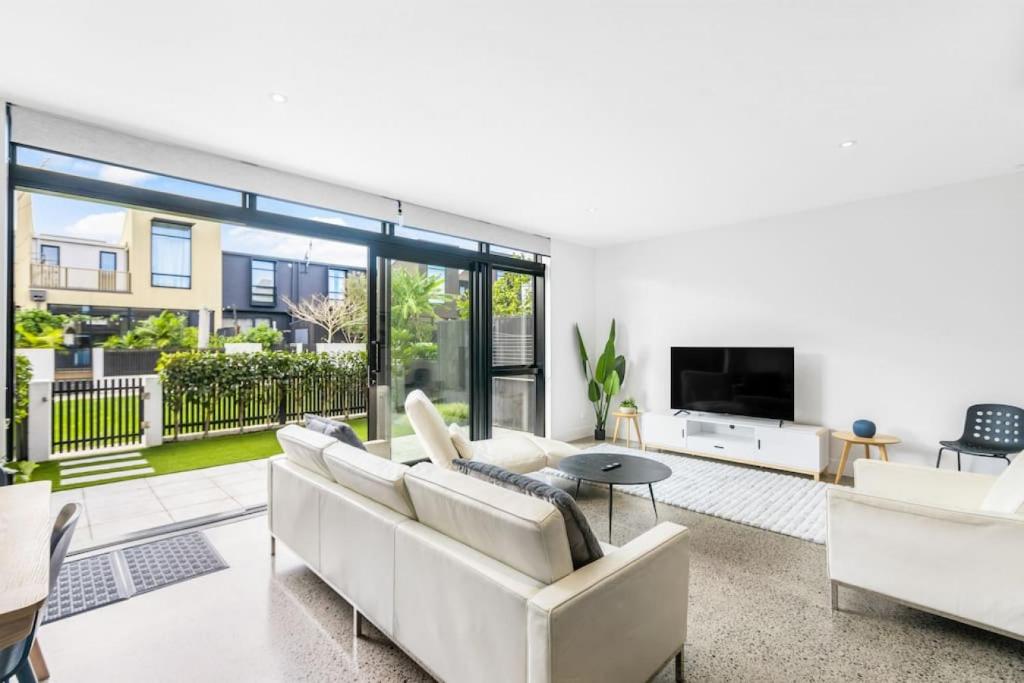 uma sala de estar com um sofá e uma televisão em 3 Bed Hobsonville Point Enchanter - WiFi - Netflix em Auckland
