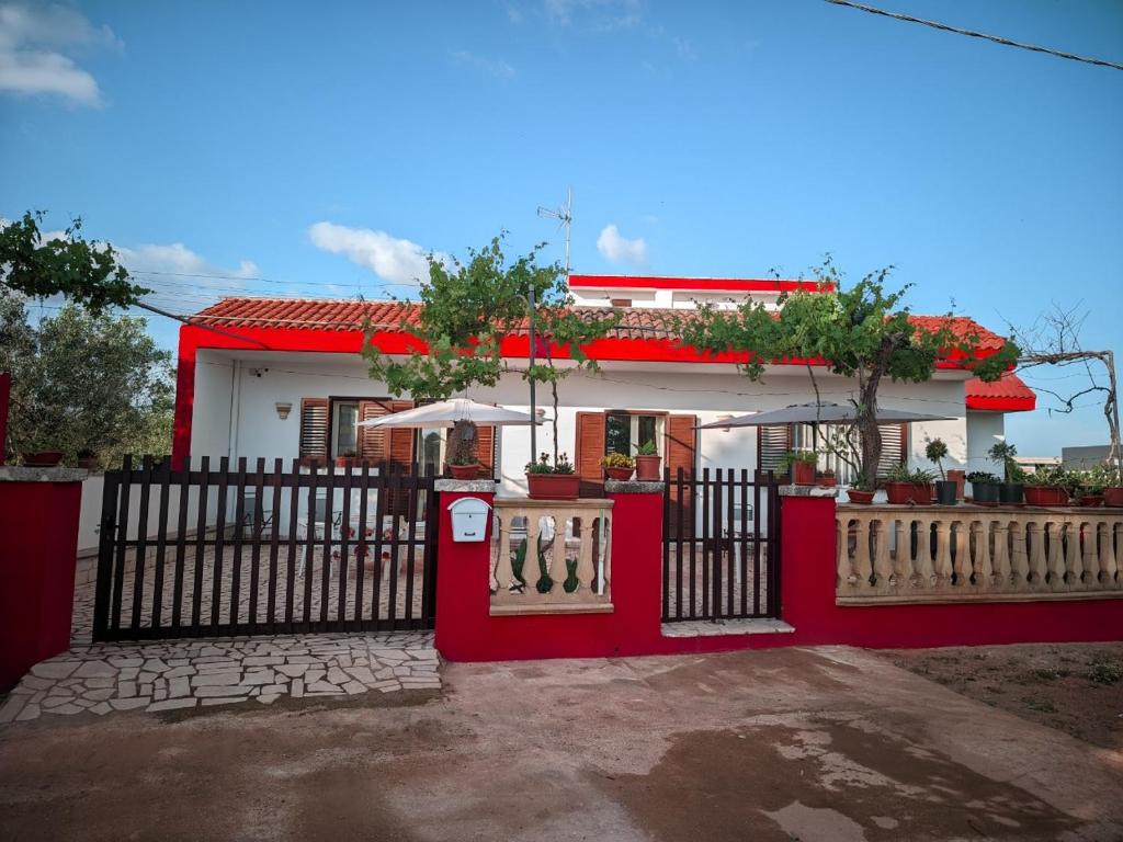 une clôture rouge devant une maison dans l'établissement Villa Nel Verde - Bonsignore, à Tricase