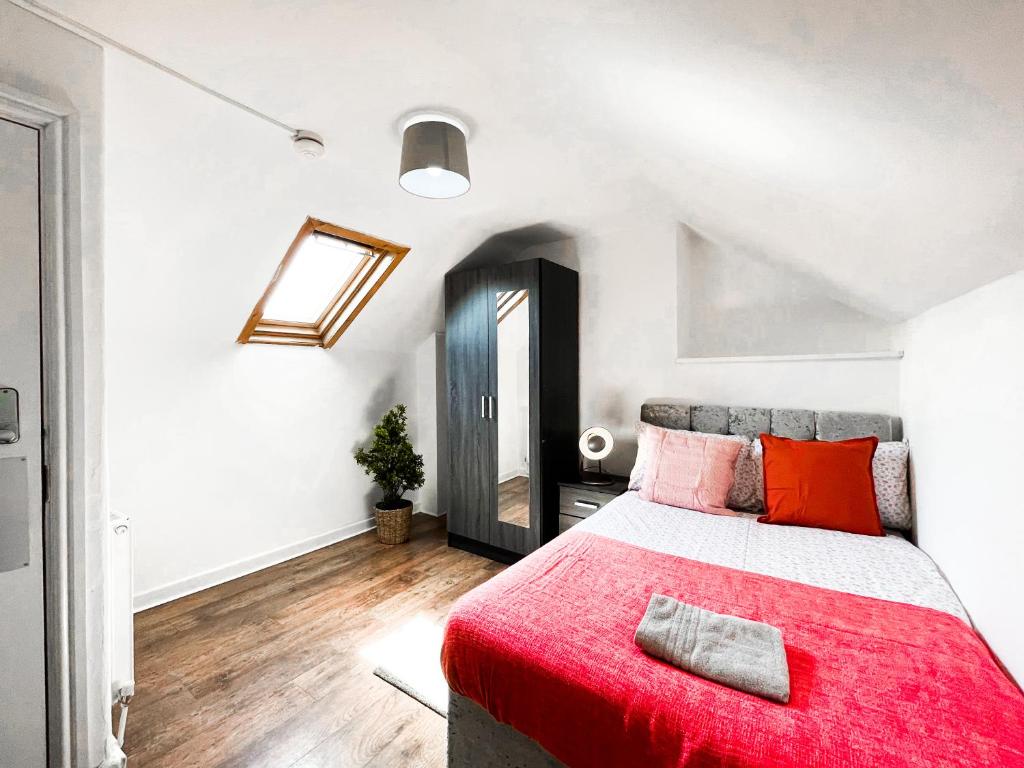 a bedroom with a large bed with a red blanket at Laid-back Midtown Retreat in Liverpool