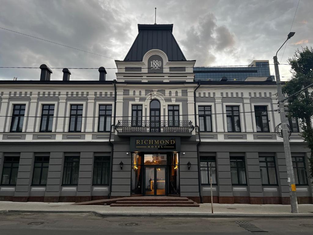 ein weißes Gebäude mit einem Uhrturm darüber in der Unterkunft Richmond Hotel in Chişinău