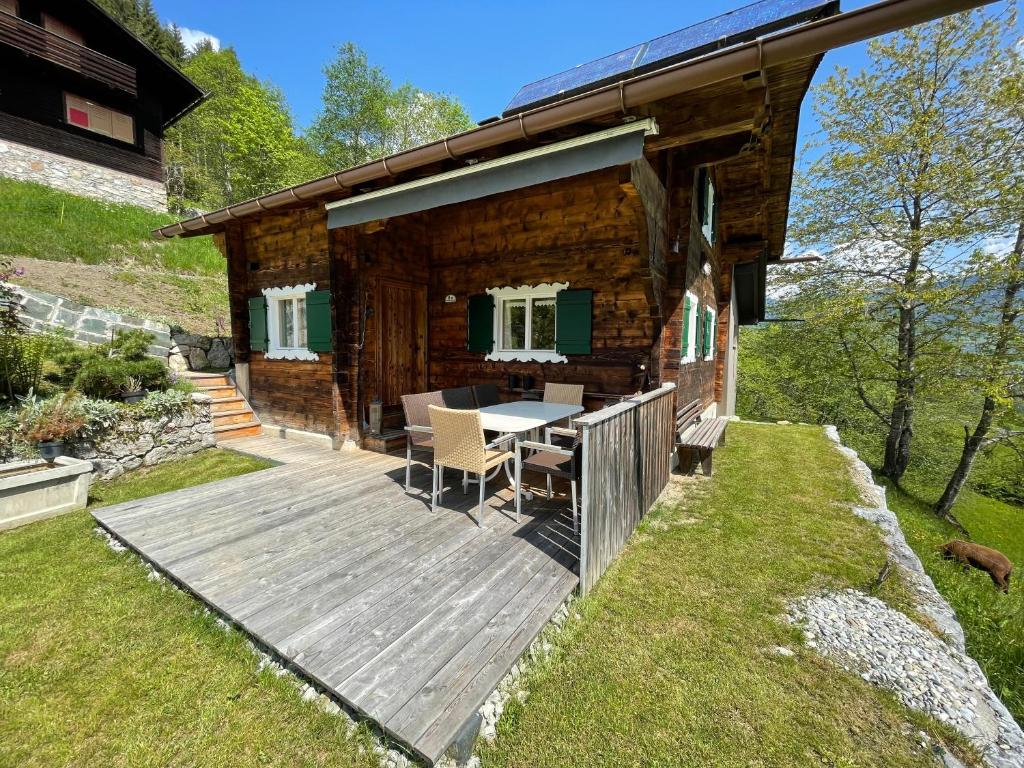 una baita di tronchi con tavolo su una terrazza in legno di Alpenchalet Piz Hüsli a Tschagguns