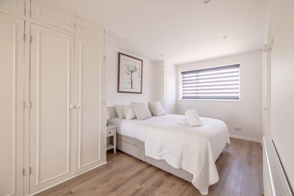 Un dormitorio blanco con una cama blanca y una ventana en Charming 3Bed 3Bath Home in Windsor with parking!, en Windsor