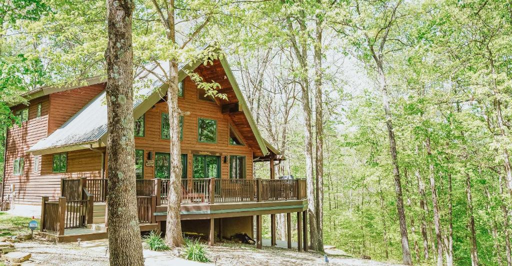 a log cabin with a deck in the woods at Paradise View Log Cabin in Nashville