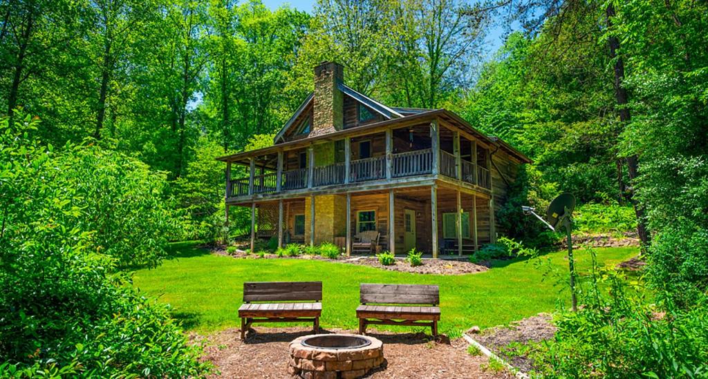 ein großes Holzhaus mit zwei Bänken davor in der Unterkunft Natures Nest in Nashville