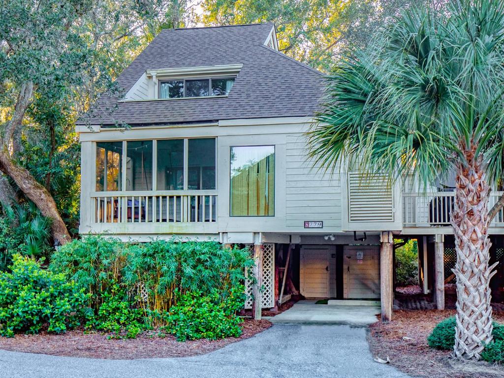 a house with a palm tree in front of it at 779 Spinnaker Beach House in Seabrook Island