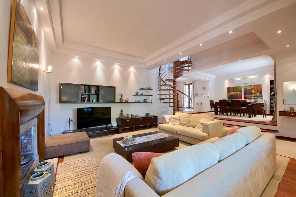 Anthemis Luxury Villa في كاليمنوس: غرفة معيشة مع أريكة ومدفأة