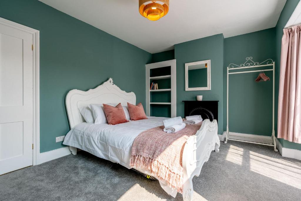 a bedroom with green walls and a white bed at Cosy Blue Shells Cottage - 2bedrooms - Garden - 5mins beach - 1min Shell Grotto in Margate