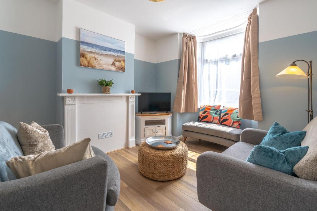 a living room with two couches and a fireplace at Cosy Blue Shells Cottage - 2bedrooms - Garden - 5mins beach - 1min Shell Grotto in Margate