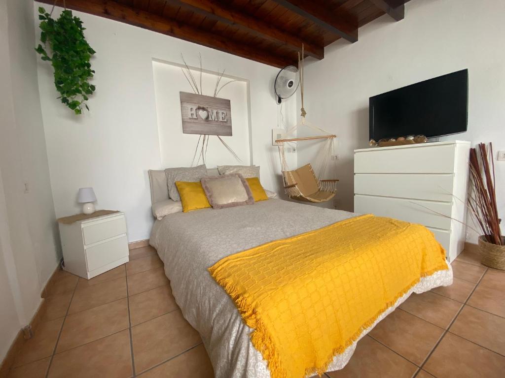 a bedroom with a bed with a yellow blanket at HAPPY HOUSE NANE in Playa Honda