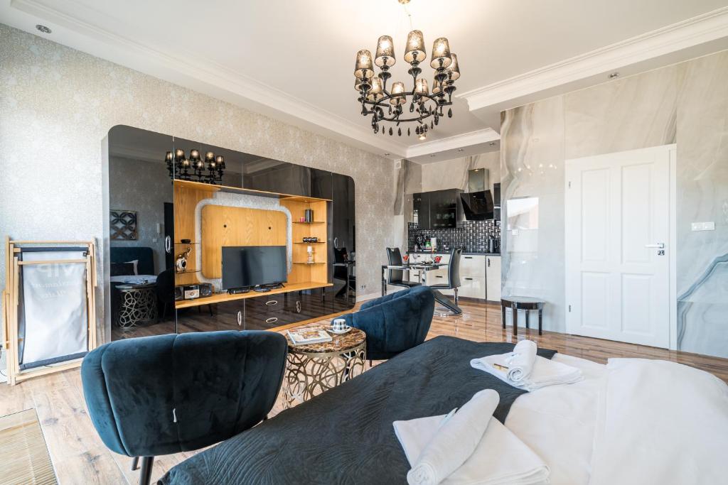 Il comprend un salon avec une table et des chaises ainsi qu'une cuisine. dans l'établissement Apartament Glamour Vip, à Ustka