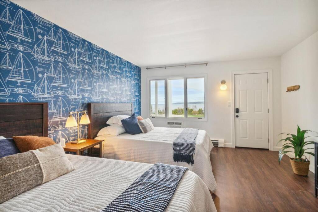 um quarto com 2 camas e uma parede azul em Breath taking Lake Views 5 min to DT Petoskey em Petoskey