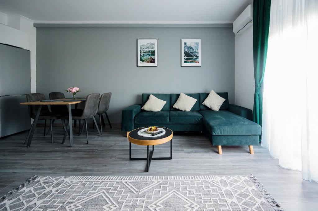 a living room with a green couch and a table at GreenForest Apartament Baile Felix in Baile Felix