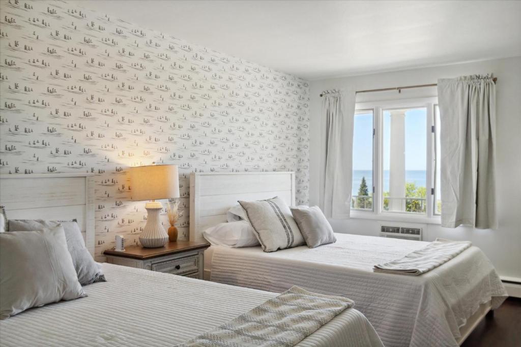 佩托斯基的住宿－Million Dollar Sunset Views of Petoskey Bay，一间卧室设有两张床和窗户。