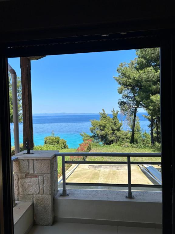 uma vista para o oceano a partir de uma janela em Cute house by the sea em Kriopigi