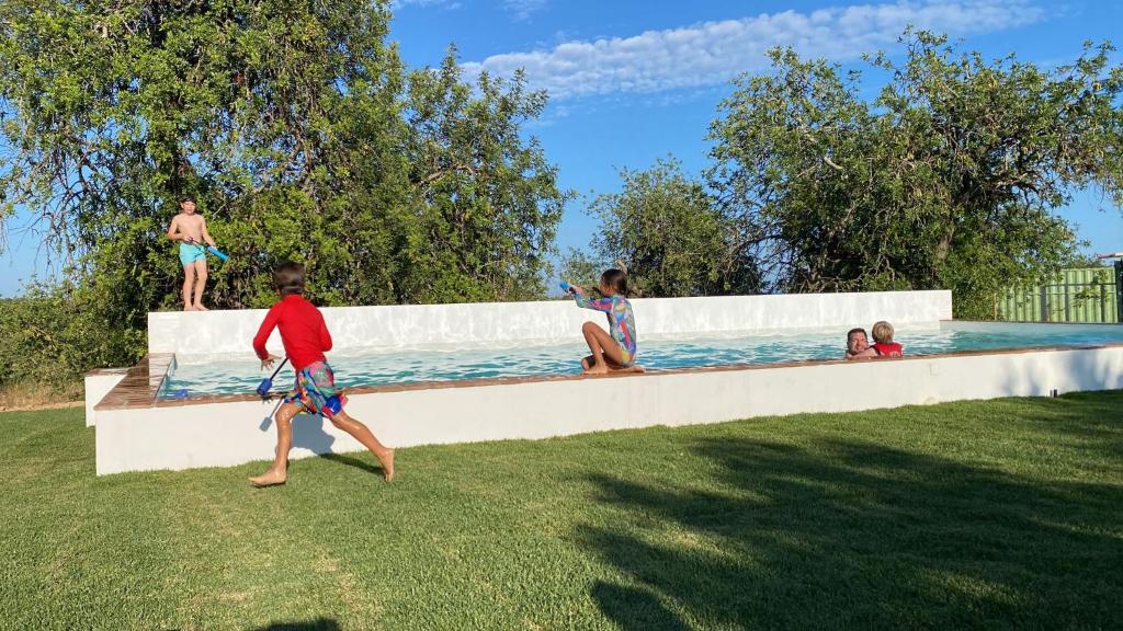 a group of children playing in a swimming pool at Tavira-Quinta da Janela Azul in Tavira
